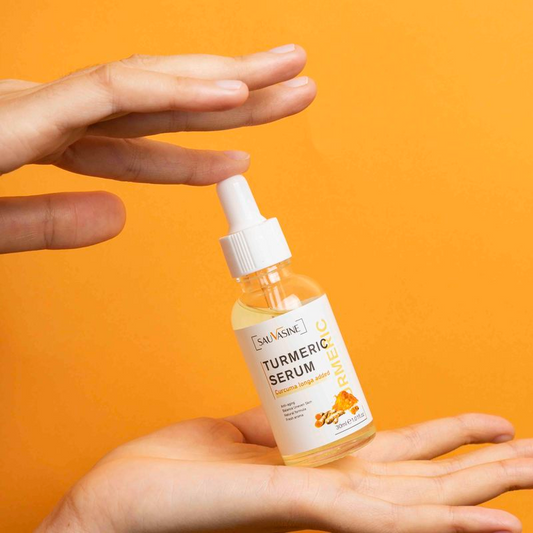 Turneric serum bottle held in a hand against an orange background